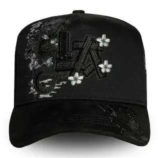 Gorra negra con logo LA en pedrería, flores blancas y detalles florales.