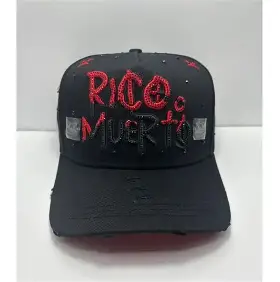 Gorra negra con frase 'Rico o Muerto' bordada en pedrería roja.