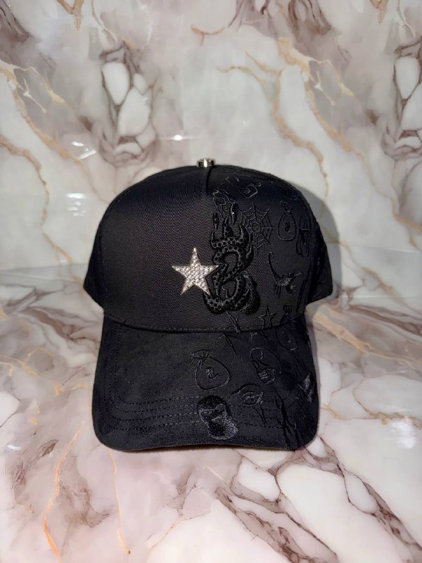 Gorra negra con estrella en pedrería y serpiente bordada en negro.